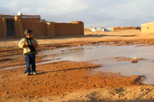 A children in Rukban is surrounded by flooded land after a rainstorm. Extreme weather is usual in the camp and causes many issues.